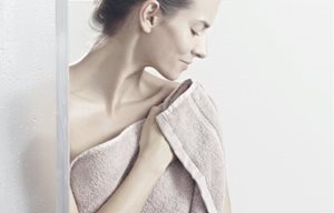 Žena tapkanjem briše kožu nakon tuširanja,