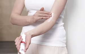 Žena nanosi Eucerin AtopiControl Akut kremu na pregib ruke.