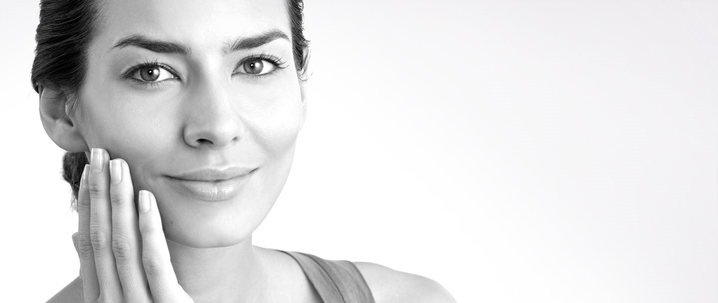 Žena srednjih godina rukom dodiruje desni obraz