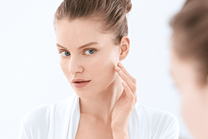 Žena rukom dodiruje svoj desni obraz