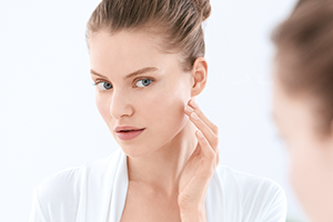 Žena rukom dodiruje svoj desni obraz