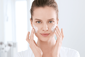 Žena na lice nanosi kremu